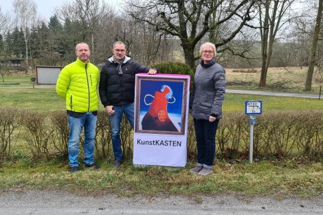 3 Personen zusammen vor einem zum Kunstkasten verhüllten Netzverteiler in einem Park in Rammenau.