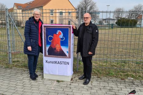 2 Personen zusammen vor einem zum Kunstkasten verhüllten Netzverteiler an einer Straße in Kamenz.