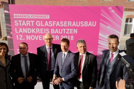 6 Personen vor einem Plakat zum Glasfaserausbau.