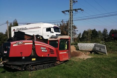 Spülbohrer in Rot auf einer Wiese. Dahinter ein weißer LKW.